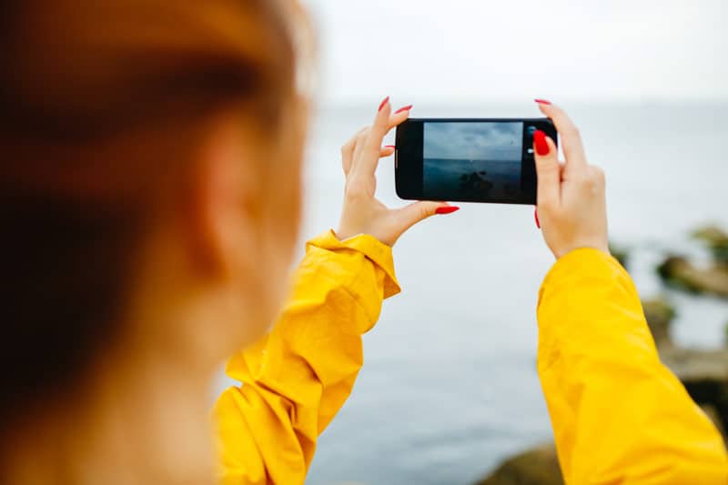 girl-taking-photo-of-ocean-PE6RWPQ_web